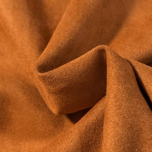 Detailaufnahme von braunem Wildlederimitat mit weicher Textur und edlem Faltenwurf