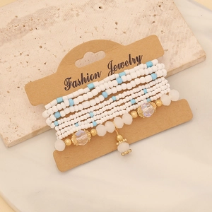 Detailed macro of layered bohemian beaded bracelets with blue and white crystals on card