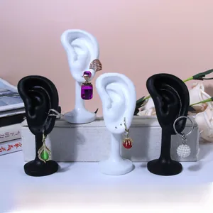 Macro display of diverse gemstone earrings and ear cuffs on silicone ear models