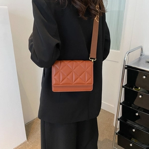 Caramel quilted leather crossbody bag with wide strap and minimalist flap design