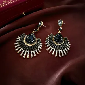Boucles d'oreilles vintage dorées avec pierres noires et glands sur soie rouge foncé