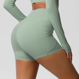 Détail du short de yoga taille haute vert sauge avec poches latérales et coutures soignées