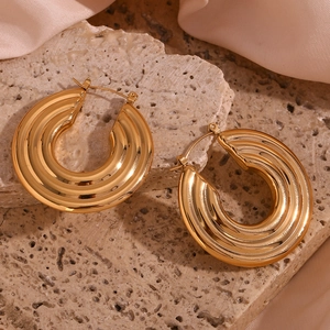 Macro shot of 18K gold plated hollow hoop earrings with textured wavy surface details