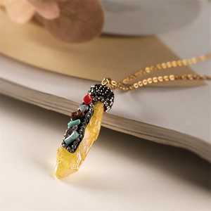 Macro shot of yellow crystal pendant with multicolor gemstones on a gold chain