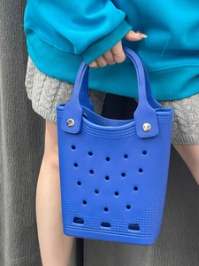 Detail view of a waterproof navy blue EVA tote bag with decorative circular holes