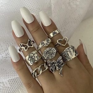 Detailed view of nine silver gothic rings featuring butterfly, heart and chain designs