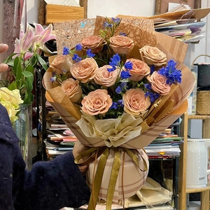 Exquisite hollow paper bouquet wrapping with pink roses and golden ribbons in hand