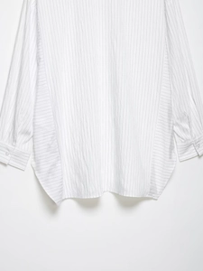 Detail of vertical stripes and single button cuff on white long sleeve shirt