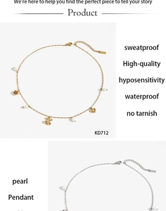 Détail d'un collier en acier inoxydable avec pendentifs cerise cœur et perle sur blanc