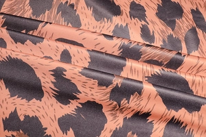 Close-up of leopard print satin fabric with silky texture and pink-brown patterns