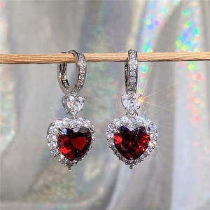 Macro shot of S925 silver earrings featuring a red heart gemstone with sparkling small diamonds