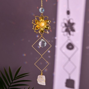Close-up of golden flower suncatcher with pink raw crystals and rainbow light refraction