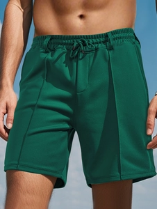 Detail of green quick-dry mesh fabric and drawstring waistband on men's beach shorts