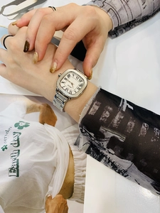 Close-up of a silver square women watch with roman numerals on a metal bracelet