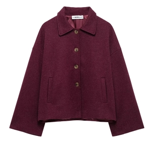 Detail of burgundy wool coat showing lapel collar, buttons, and thick textured fabric