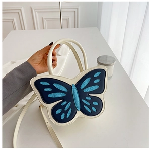 Detail of creative butterfly-shaped handbag with navy blue wings and sparkling sequins