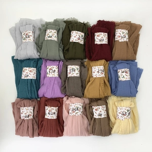 Flat lay of 15 pleated cotton viscose scarves showing various colors and textures