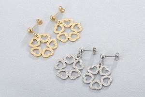 Detailed view of hollow heart flower pendant earrings in gold and silver finishes