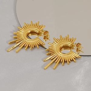 Macro detail of sunburst titanium steel earrings with golden finish and radiating spokes