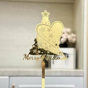 Gros plan d'une décoration de gâteau en acrylique doré avec texte de Joyeux Noël