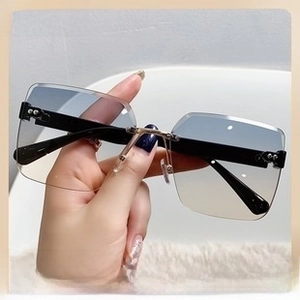 Close-up of rimless butterfly sunglasses with gradient lenses and gold metal bridge