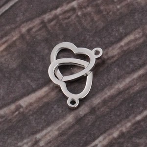 Macro detail of interlocked double heart stainless steel connectors on dark wood