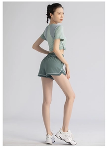 Detail view of women's two-piece fitness set with knotted short sleeve top and shorts