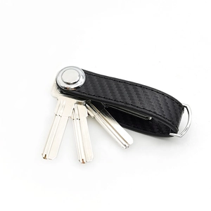 Close-up of black carbon fiber key organizer with metal ring and four silver keys