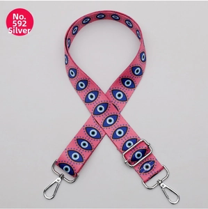 Detail of pink ethnic evil eye printed bag strap with silver metal lobster clasps