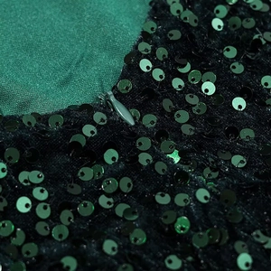 Detailed macro view of green sequined fabric panel with a hidden zipper closure