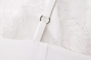 Macro view of white lace texture with metal ring detail on the strap of the top