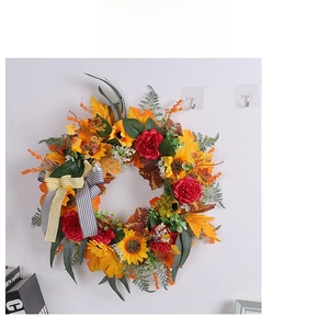 Dettaglio ghirlanda autunnale con girasoli, foglie di acero e decorazione a doppio fiocco