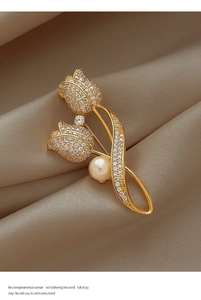 Macro detail of tulip brooch with pave diamonds and a large center pearl on champagne silk