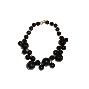 Exaggerated black oversized irregular bead necklace with glossy finish and metal clasp
