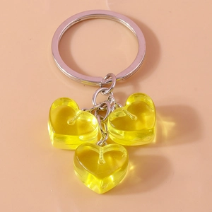 Detail of three translucent yellow jelly heart charms on a silver keychain link