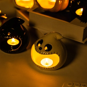 Ceramic Halloween ghost and pumpkin candle holders with warm glowing candle light
