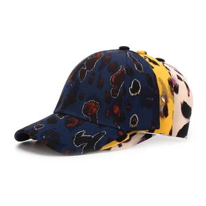 Close-up of leopard print baseball caps with glitter gold outline and stiff curved brim