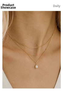 Detail of double-layer 18k gold plated necklace with freshwater pearl pendant on model