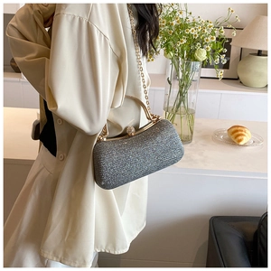 Detailed view of silver sequin clutch bag with gold frame and chain strap for evening events