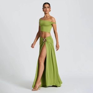 Detail of green two-piece set featuring a metal waist buckle and high side slit skirt