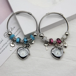 Detail of beaded flower bracelets with heart-shaped watch pendants in blue and pink tones