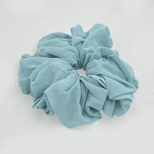 Close-up of oversized dusty blue chiffon hair scrunchie with pleated fabric texture