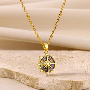 Detail of vintage gold starburst pendant with dark mother of pearl inlay on natural stone