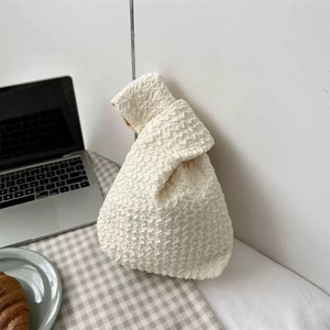 Detailed texture of a white bubble fabric knot bag placed on a cozy daily scene table
