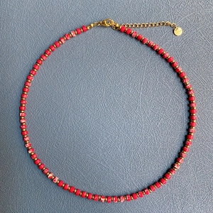 Handmade bohemian beaded necklace with red marble stones and gold spacers in a circular layout