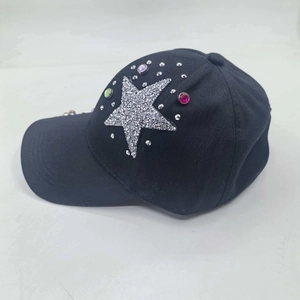 Detail of multi-color rhinestones and silver glitter star on a black baseball cap