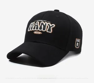 Close-up of black baseball cap showing 3D embroidered letters and side badge detail