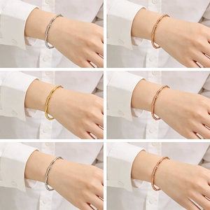 Dettaglio di bracciali minimalisti a forma di bambù in finiture argento, oro e rosa