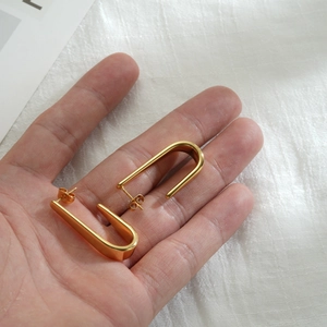 Minimalist U-shaped geometric stainless steel earrings with 18k gold plating in hand