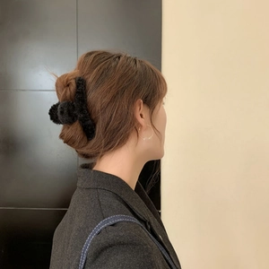 Eleganter schwarzer Plüsch-Haarclip für Damen in der Seitenansicht am Haar